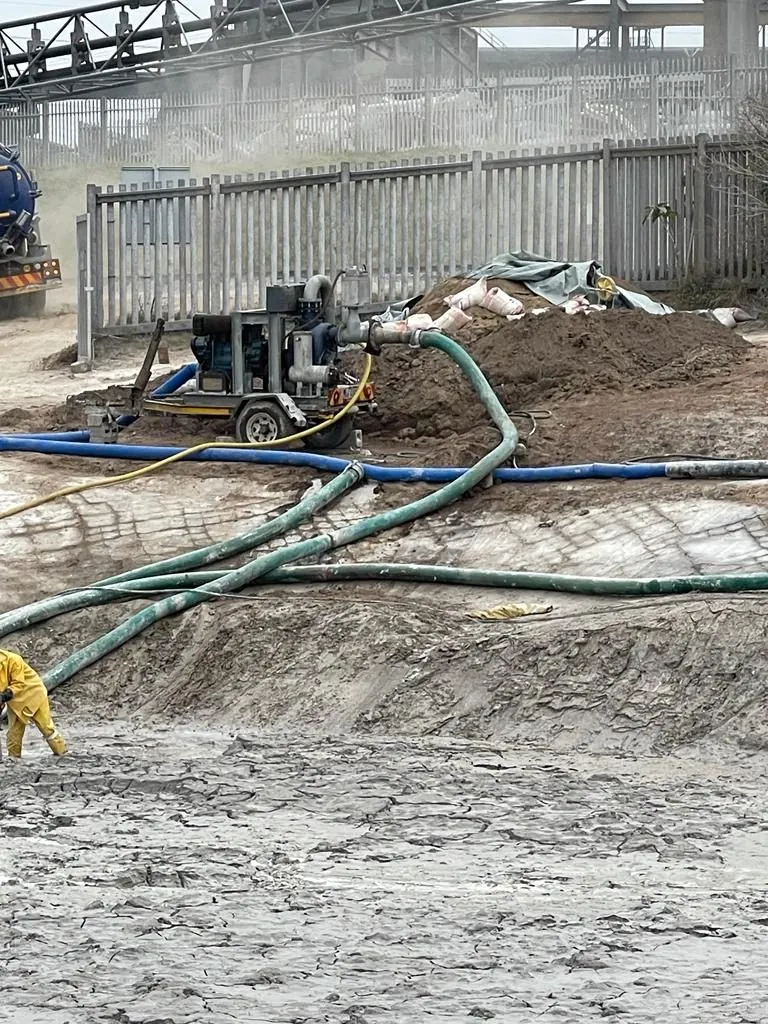 Sludge pump in operation with worker in PPE