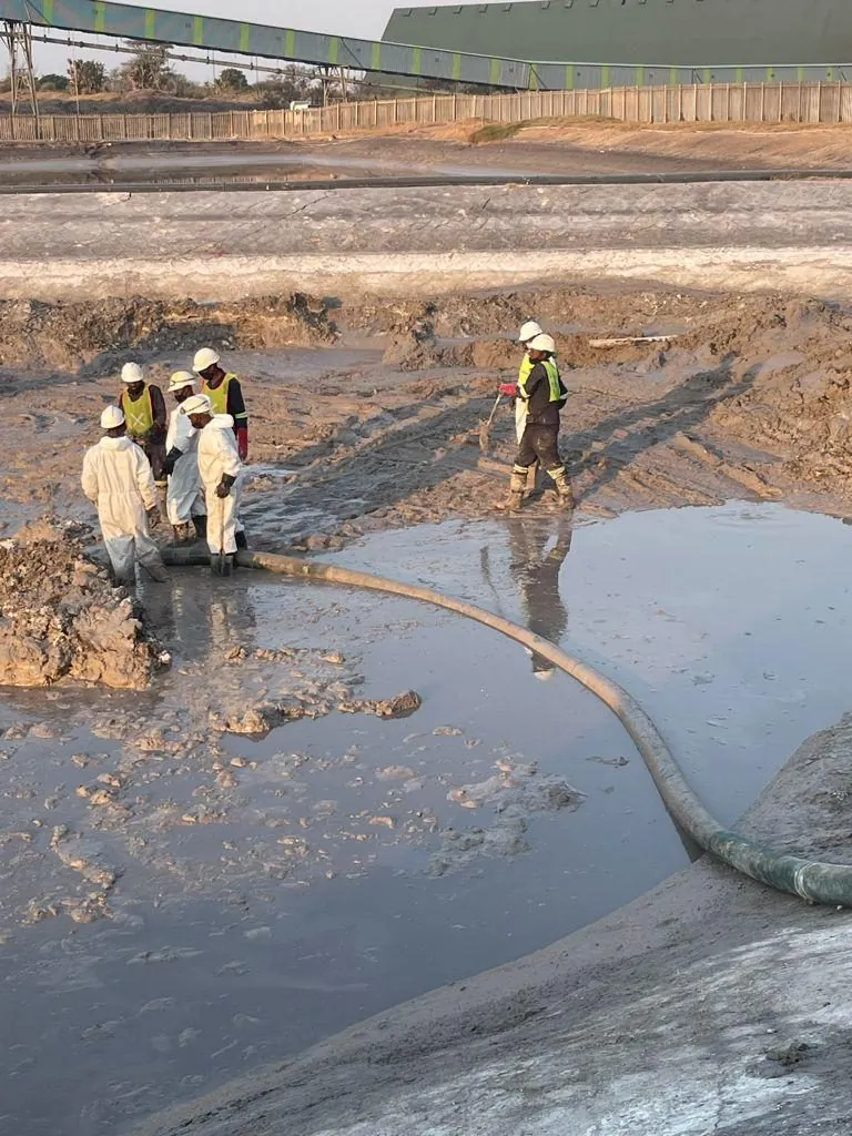 Crew working alongside a skid steer loader in a tailings dam